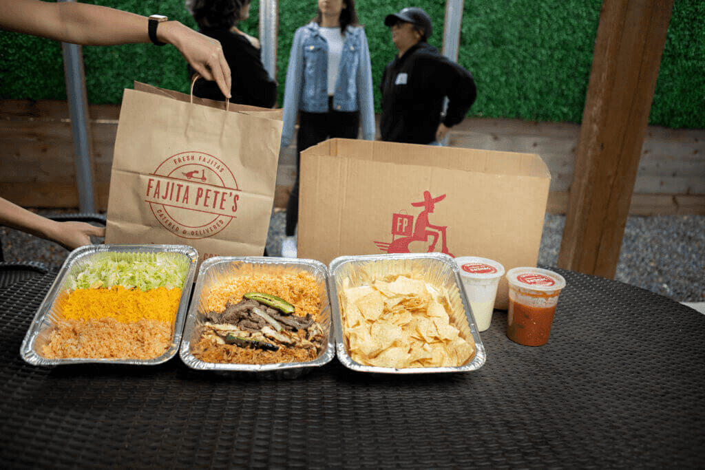 Fajitas in catering pans and large catering bags in background